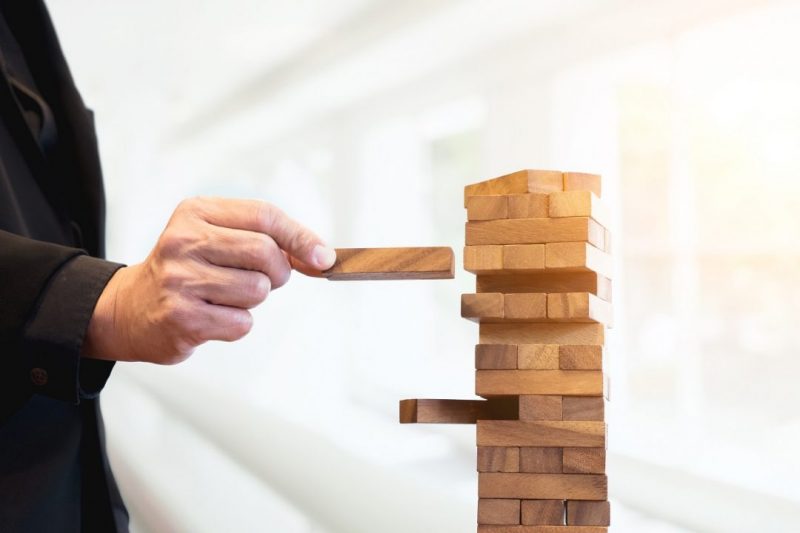 Planning, risk and strategy of project management in business, businessman and engineer gambling placing wooden block on a tower.Business and construction concept.